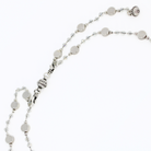 Silver necklace with round beads on a white background showing how to put on the clasp