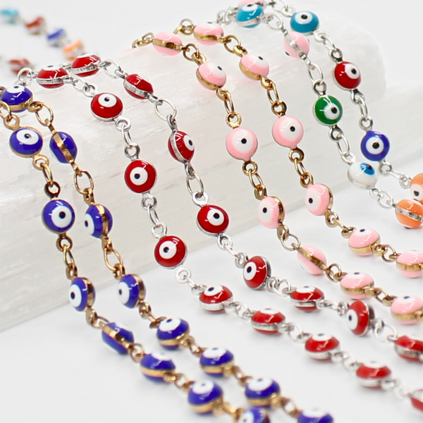 Colorful evil eye beaded necklaces on a white surface