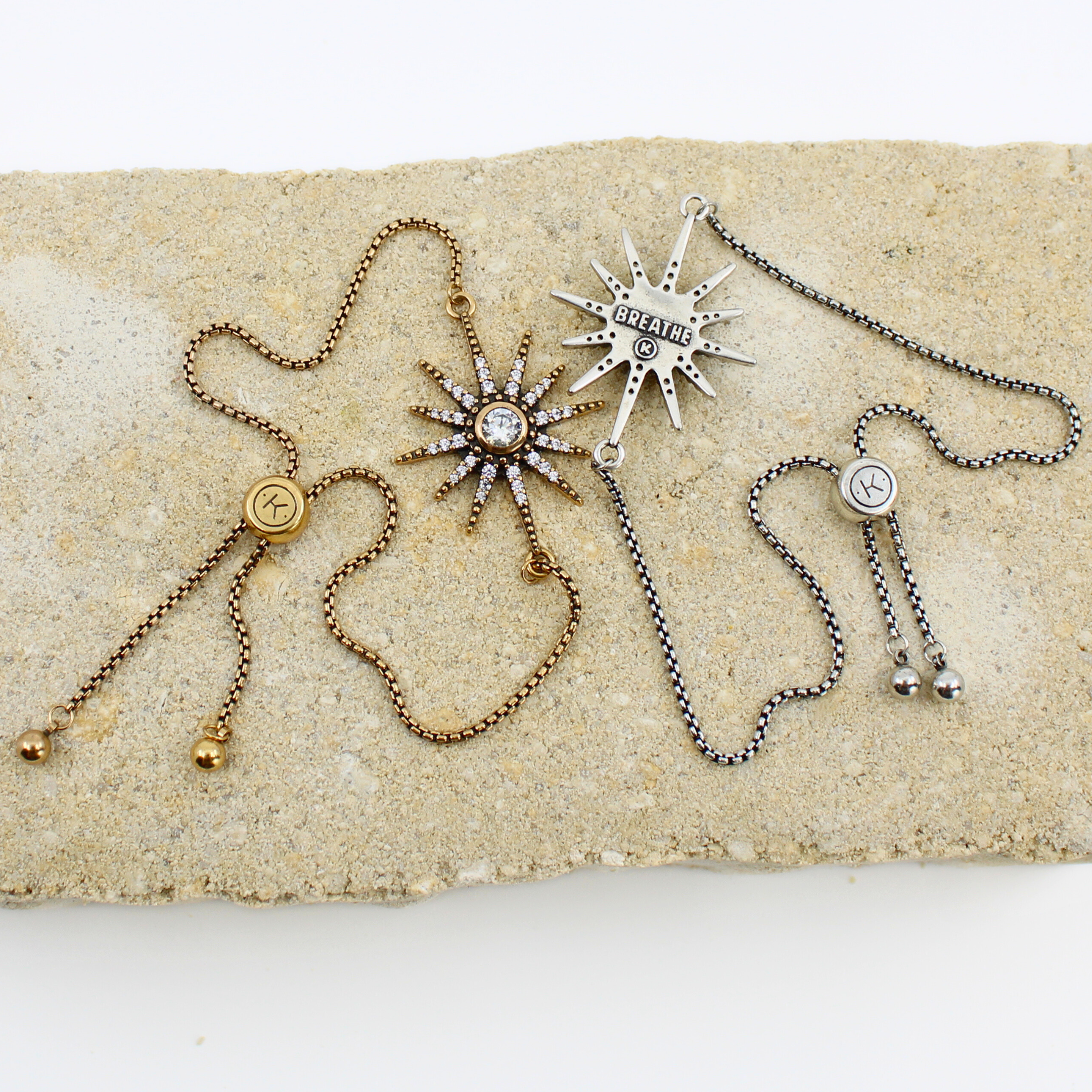Three necklaces with star-shaped pendants on a textured surface
