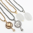 A collection of beaded necklaces with crystal elements, available in gold or silver finish, some with a 'I Am Enough' inscription.