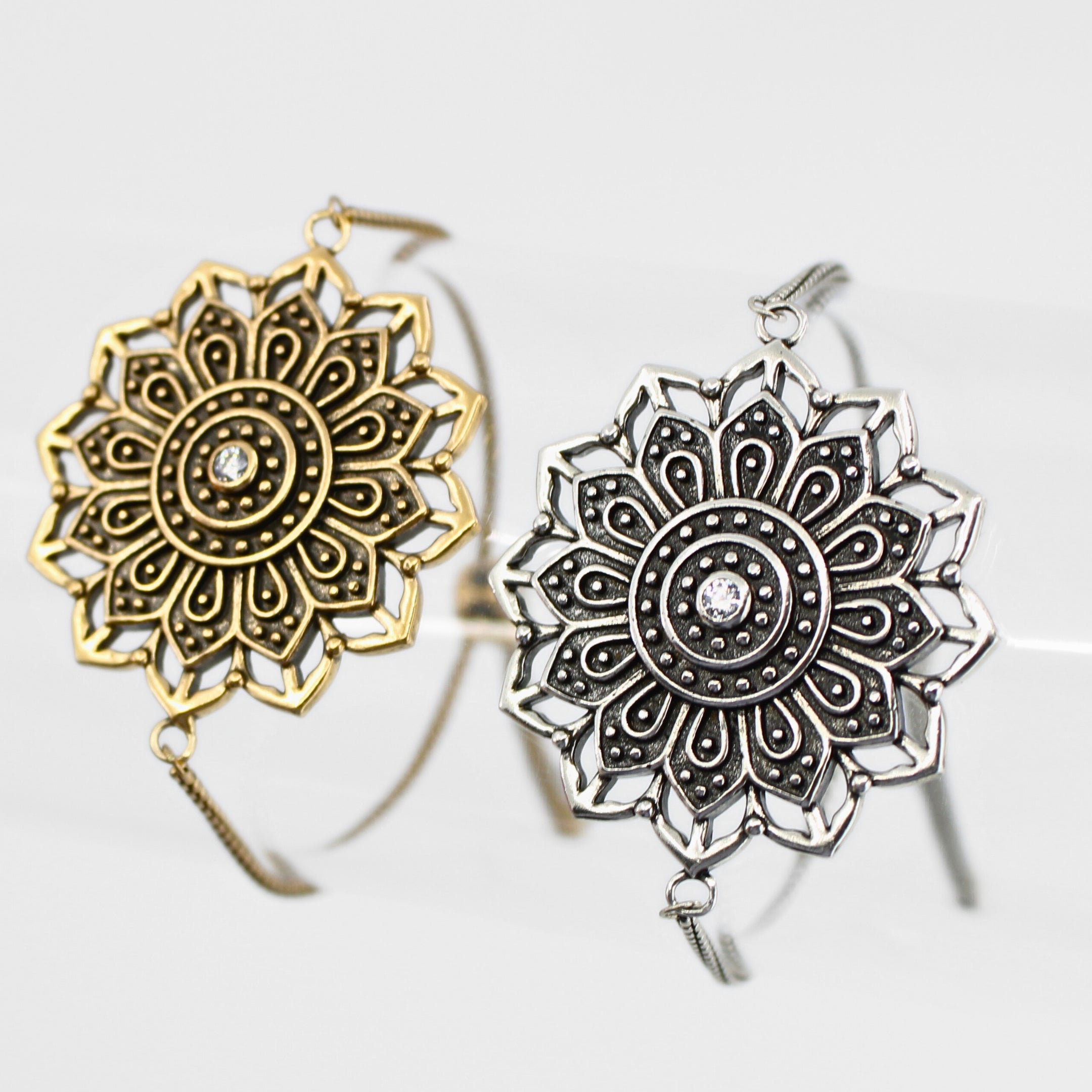 Gold and silver mandala-style earrings on a white background