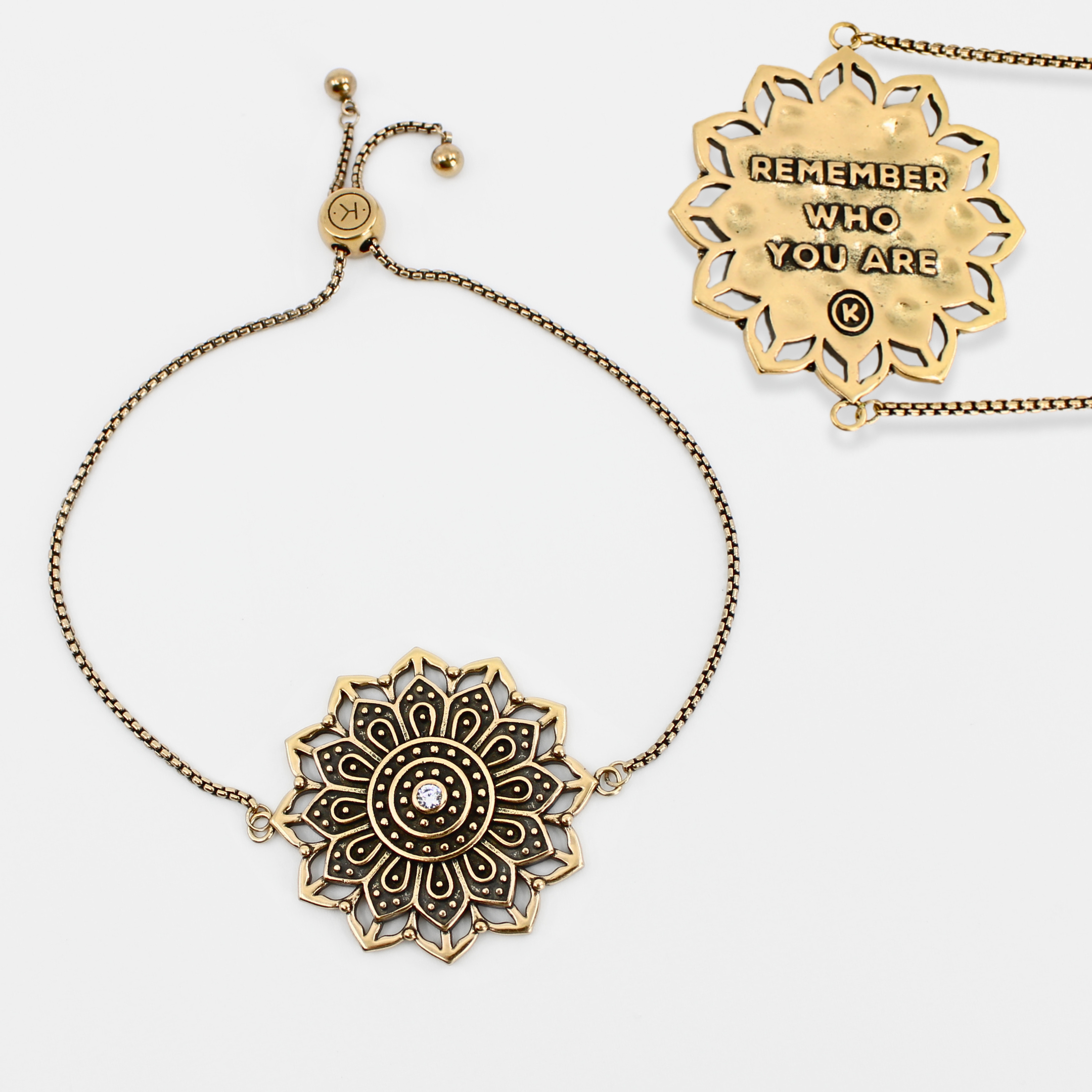 Gold mandala-style necklace with motivational pendant on a white background