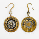 Pair of gold and bronze earrings with floral designs on a white background
