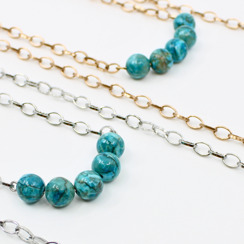 Stainless steel necklace featuring a gold  or silver chain with a row of five Aqua Terra Jasper beads, beautifully marbled in blue, set against a pristine white background. Perfect for layering.