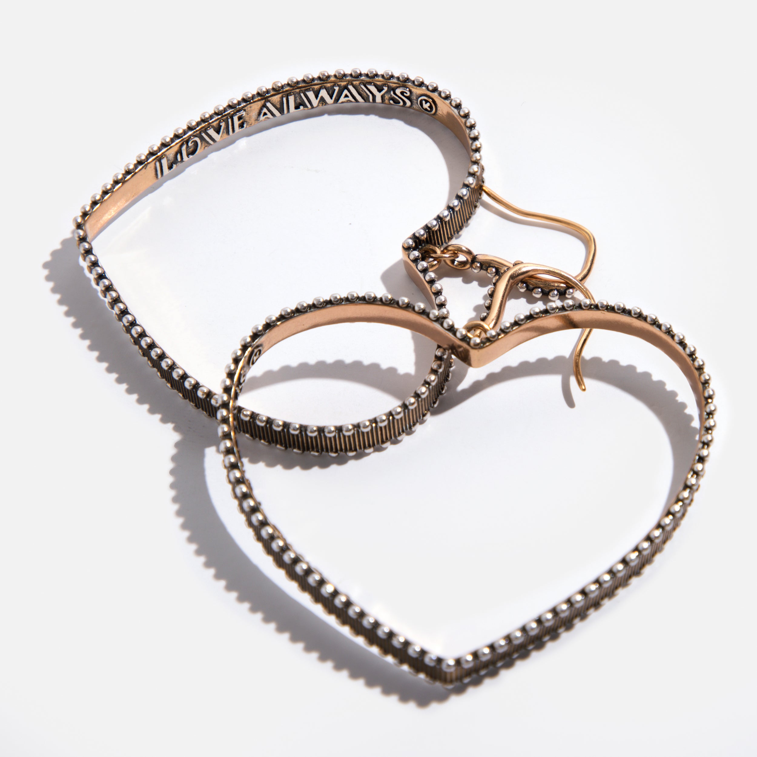 A pair of gold-tone open heart drop earrings with a message inscribed inside, attached to French ear wires.