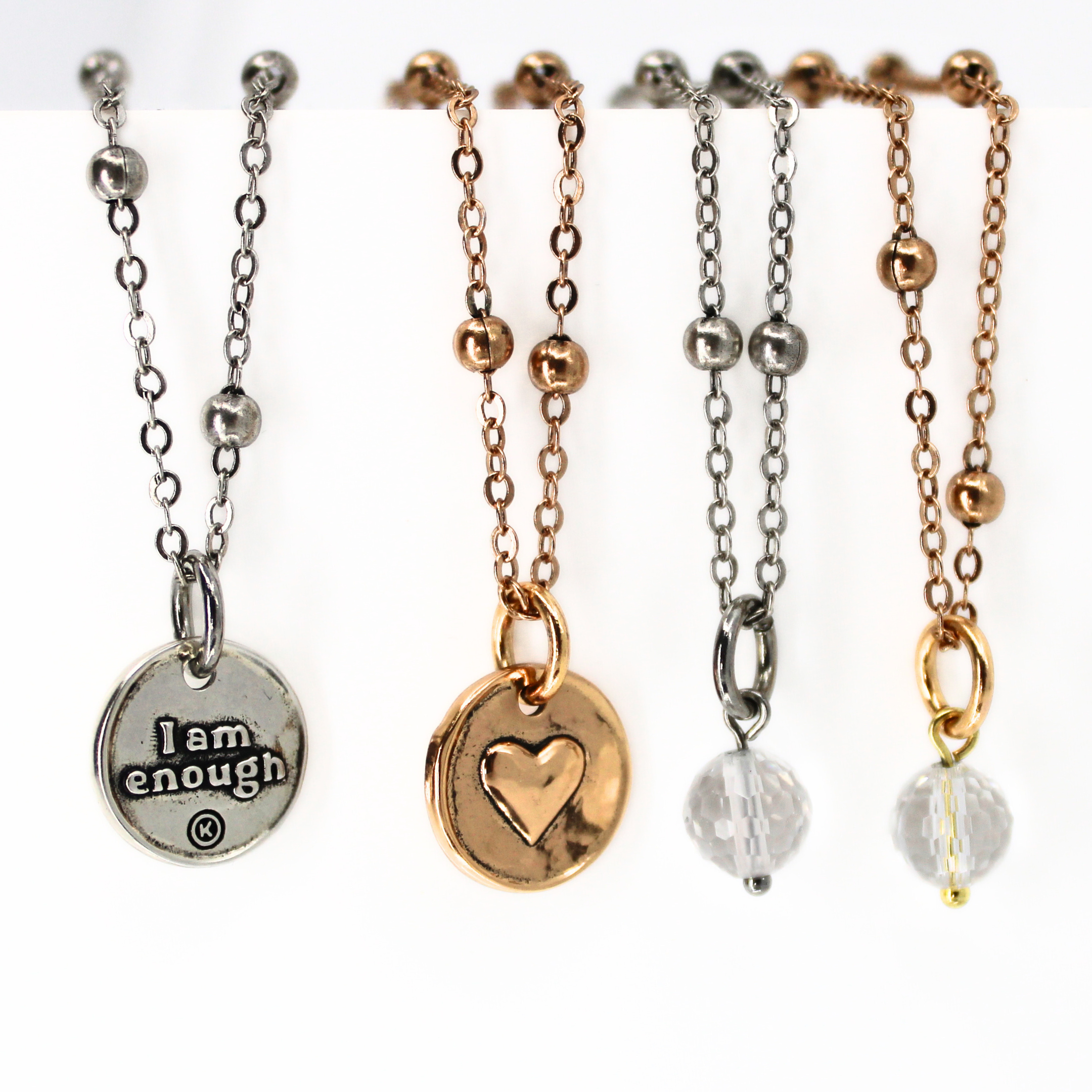 A collection of dainty necklaces with spherical and round pendants in gold and silver colors, displayed on a white background.