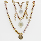 Multistrand beaded necklace with decorative elements on a white background