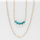 Stainless steel necklace featuring a gold chain with a row of five Aqua Terra Jasper beads, beautifully marbled in blue. Perfect for layering.