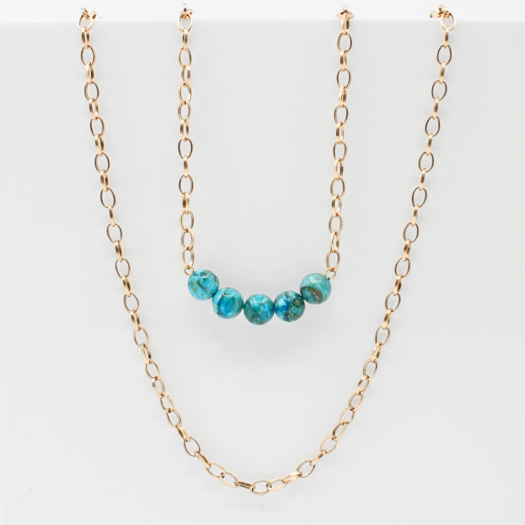 Stainless steel necklace featuring a gold chain with a row of five Aqua Terra Jasper beads, beautifully marbled in blue. Perfect for layering.