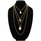 A collection of layered necklaces with various beads and clasps, featuring gold and silver finishes, with one necklace having a pendant that reads 'Remember who the f*** you are'.