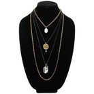 A collection of layered necklaces with various beads and clasps, featuring gold and silver finishes, with one necklace having a pendant that reads 'Remember who the f*** you are'.