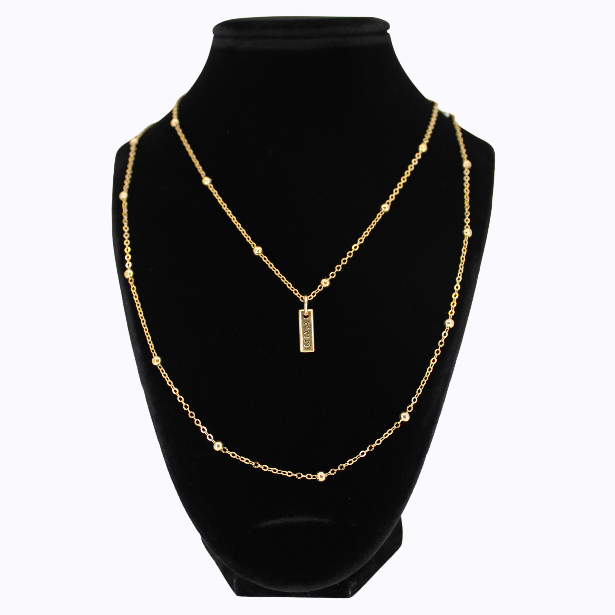 Gold necklace with a pendant on a black mannequin bust