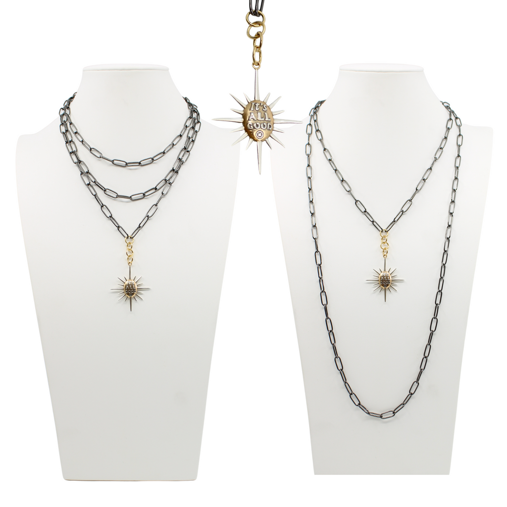 sunburst pendants on chains; one says Its all good and features a mix of silver and gold tones. both on a sleek gunmetal chain, offering a modern twist with its subtle magnetic clasp for easy wear.