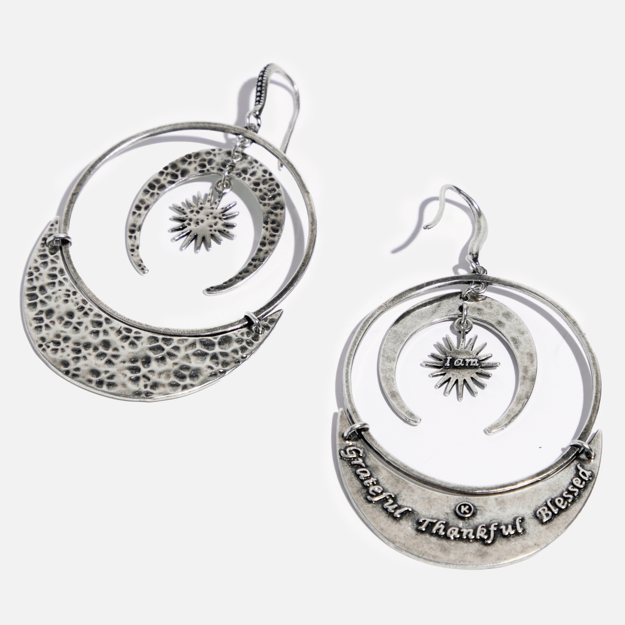 A pair of drop earrings with a hammered texture and a message inscribed on one side, available in two colors: one with an antique gold finish and the other with an antique silver finish, both featuring a star and moon design.