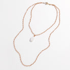 Handmade jewelry at its finest, this gold chain necklace features a white stone pendant elegantly displayed against a white background.