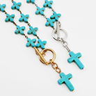 Necklace with turquoise cross pendants and gold and silver clasps on a white background