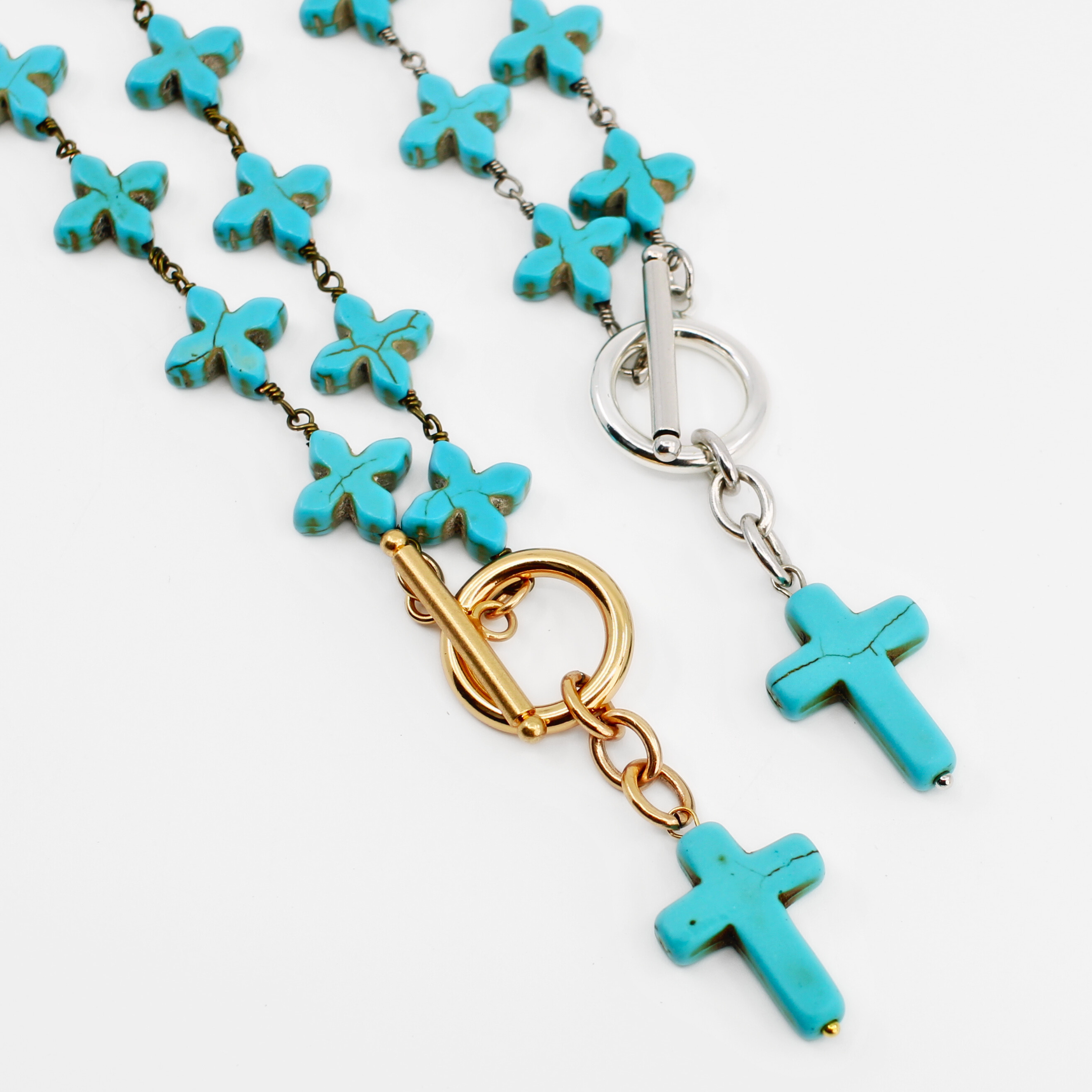 Necklace with turquoise cross pendants and gold and silver clasps on a white background