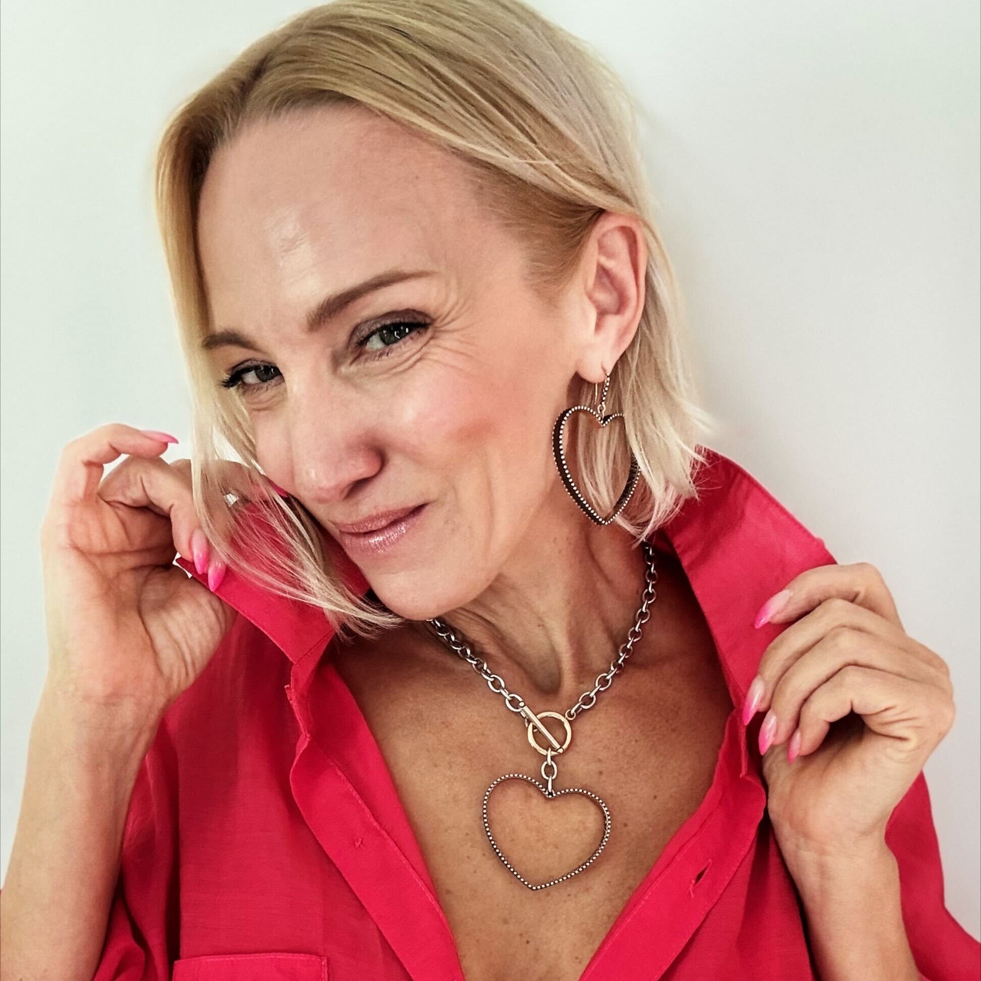 love always open heart mix metal statement choker necklace from katia designs. pictured on model with love always collection. statement choker necklace adorned with a large hollow heart pendant, showcasing a two-tone design embellished trim and a heartfelt inscription. 