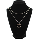 A jewelry display features a black velvet bust showcasing a necklace with delicate silver chain. The chain, with a magnetic clasp, displays an open heart pendant adorned with small MIX METAL DETAILS AND TRIM AND INSCRIBED WITH love always INSIDE.