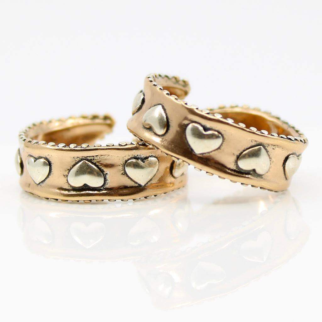 New gold rings with heart details showcase their charm. They are open-ended, offering an adjustable fit with unique heart design. Inside, they are adorned with engraved text that reads LOVE ALWAYS.