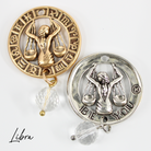 Two necklaces with gold and silver chains, featuring circular pendants with zodiac signs, and faceted crystal quartz accents.