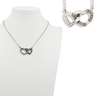 Silver necklace with interlocking heart pendants on a white background