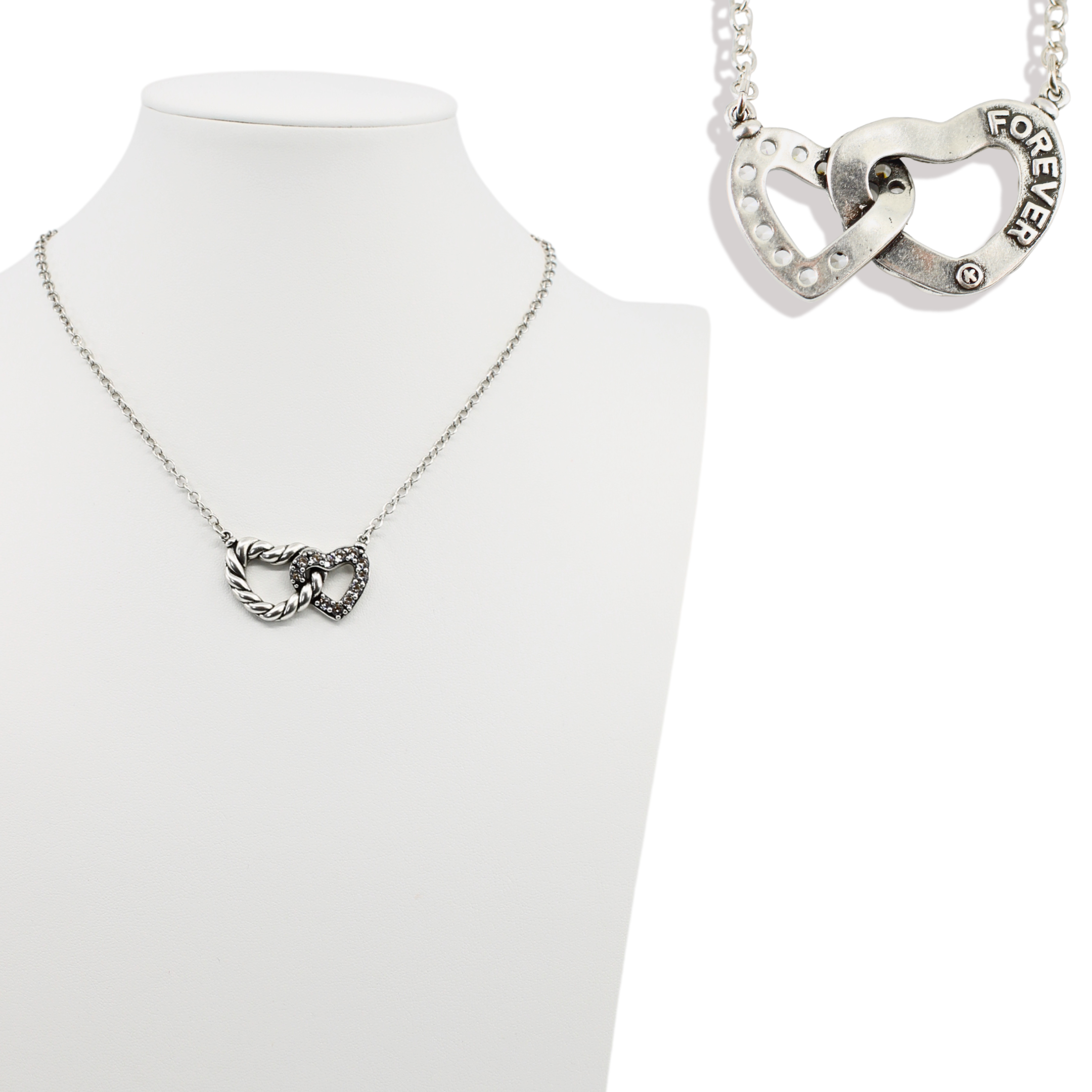 Silver necklace with interlocking heart pendants on a white background