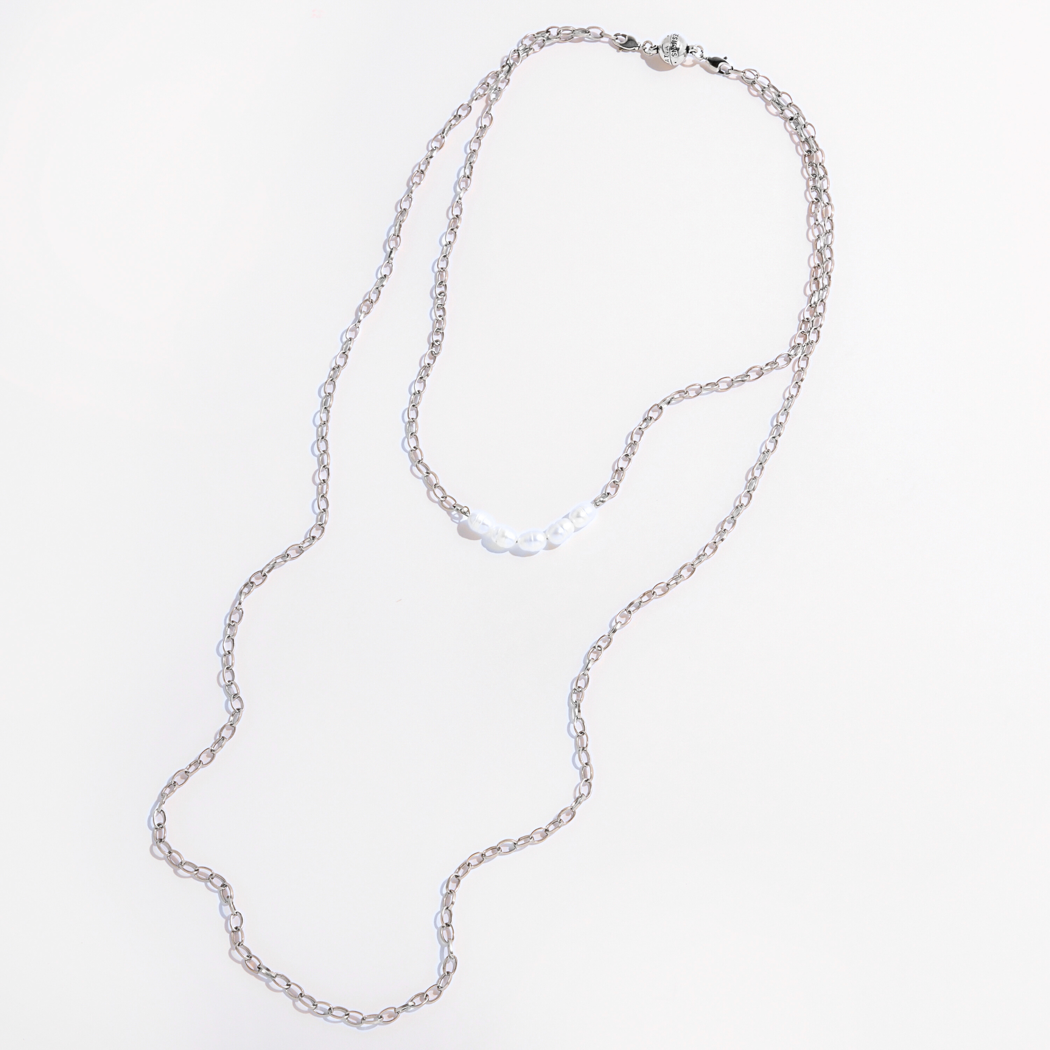 Two layering chain necklaces with pearl accent stones, one plated in gold and the other in silver, displayed against a white background.