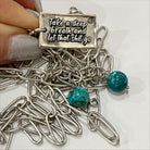 A brass necklace with a paperclip chain design, featuring a rectangular pendant with a heart cut-out and two magnesite accent stones on a white background.