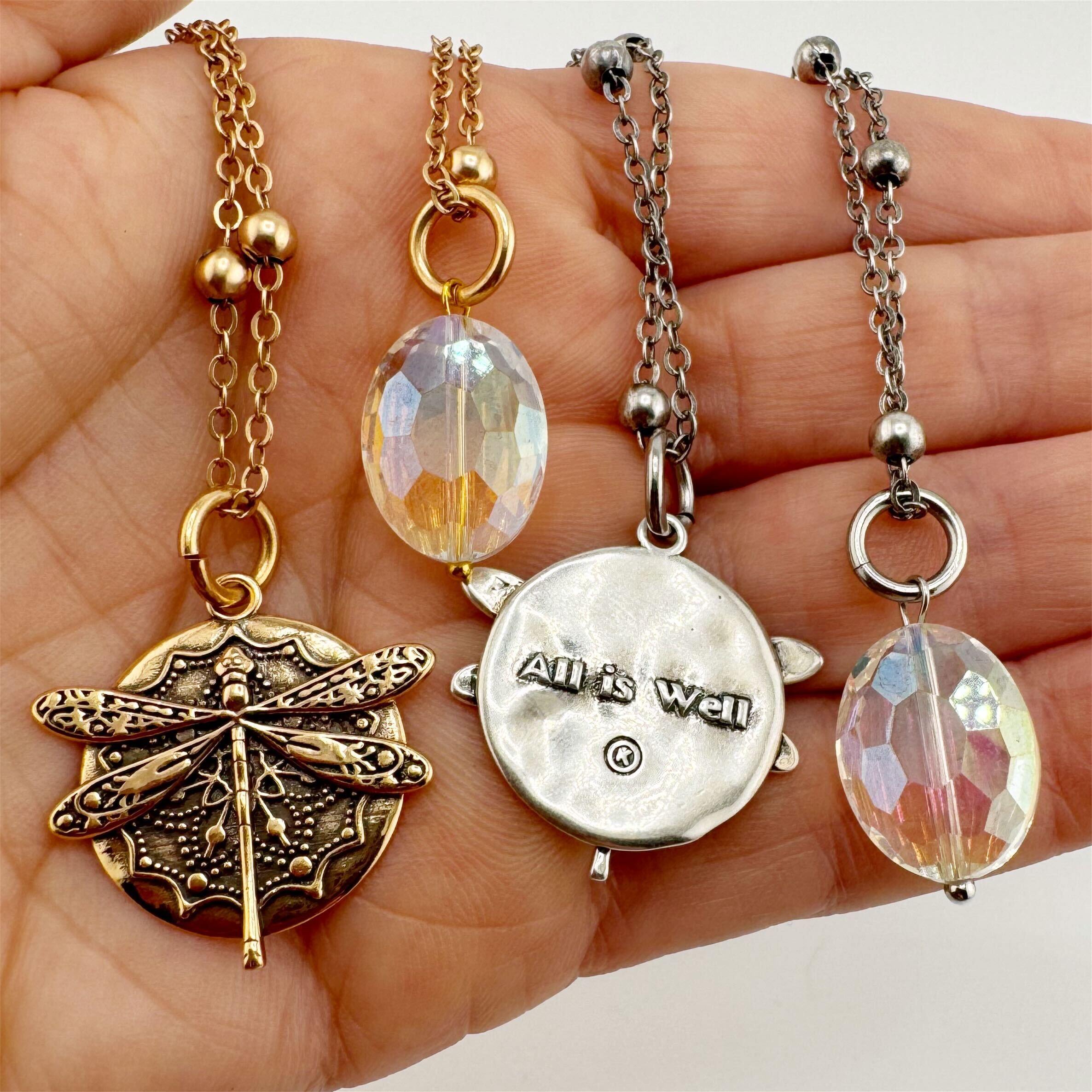 dragonfly pendant detail in gold and silver with message on back reads "all is well"