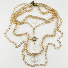 Gold chain necklace with beads and a star pendant on a white background