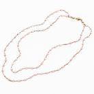 Pink beaded necklace on a white background
