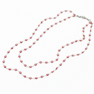 Long necklace with red and white beads on a white background