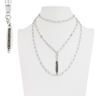 Silver chain necklace with pendant on a mannequin bust against a white background