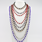 Multicolored beaded necklaces on a white mannequin bust against a white background