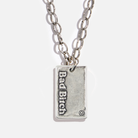 Silver necklace with a pendant that reads 'Bad Bitch' on a white background