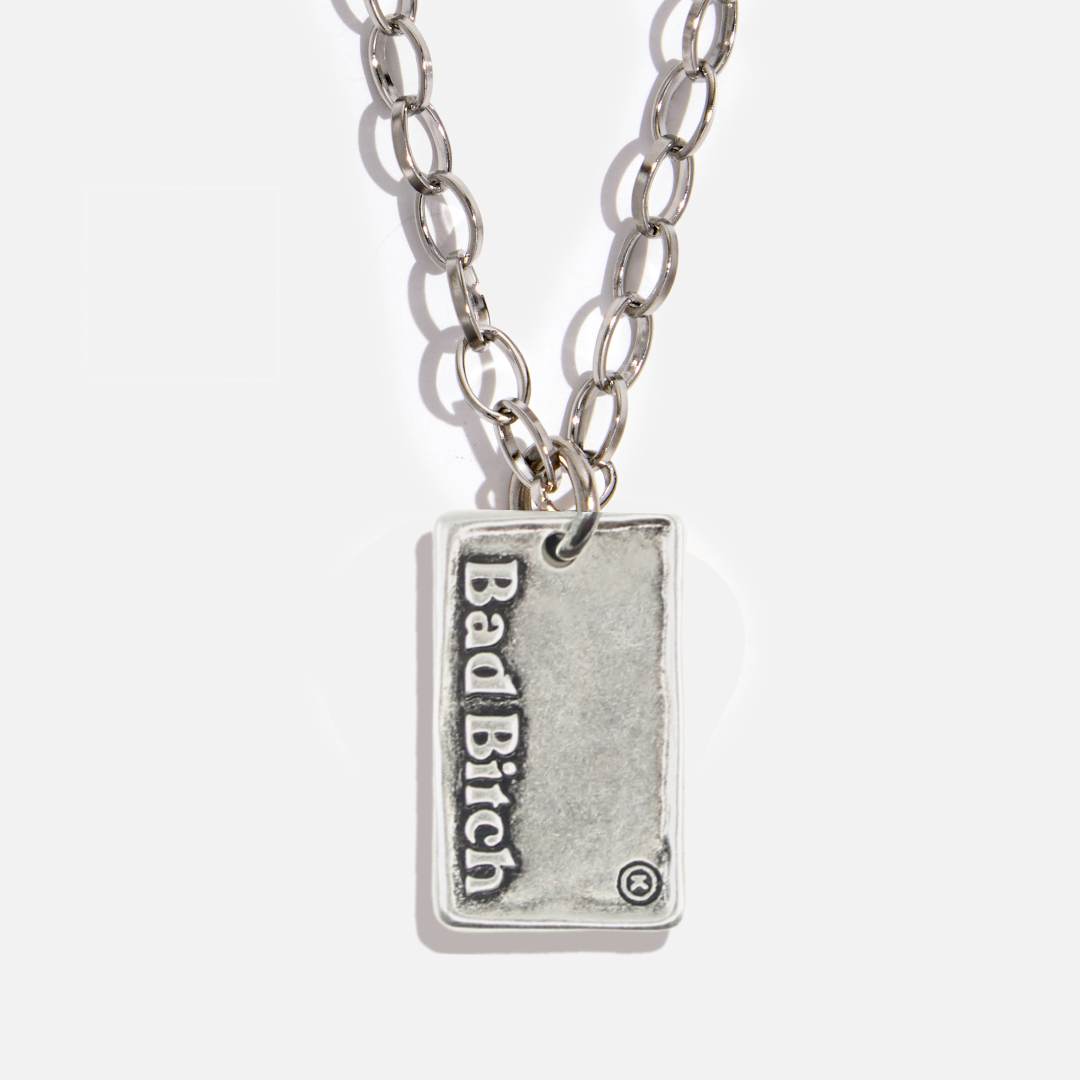 Silver necklace with a pendant that reads 'Bad Bitch' on a white background