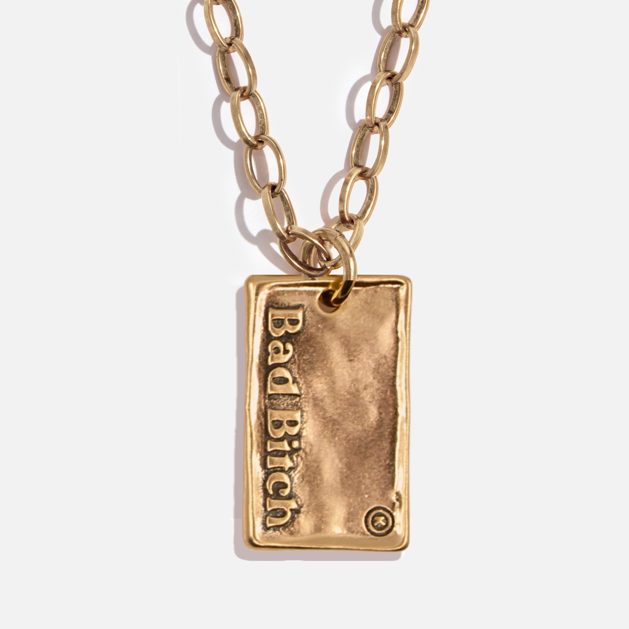 Gold necklace with a rectangular pendant engraved with 'Bad Bitch' on a white background