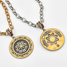 Two gold and silver necklaces with intricate pendants on a white background