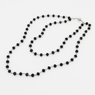 Black beaded necklace on a white background
