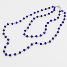 Long necklace with blue beads on a white background
