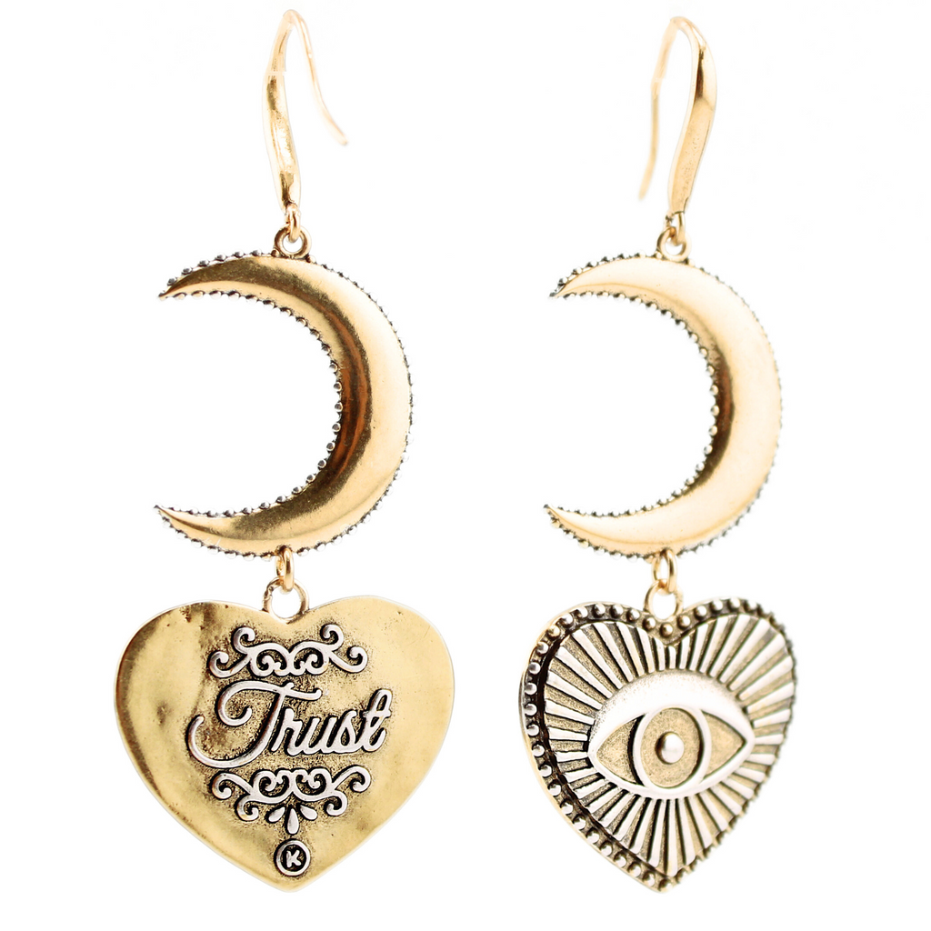 Gold earrings with crescent moons and heart-shaped pendants featuring eye designs, crafted in a mixed metal design. The pieces elegantly suspend from French ear wires, creating a captivating composite drop earring effect.