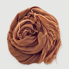 Brown scarf with fringes on a light gray background