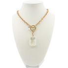 Gold necklace with a clear pendant on a mannequin bust against a white background