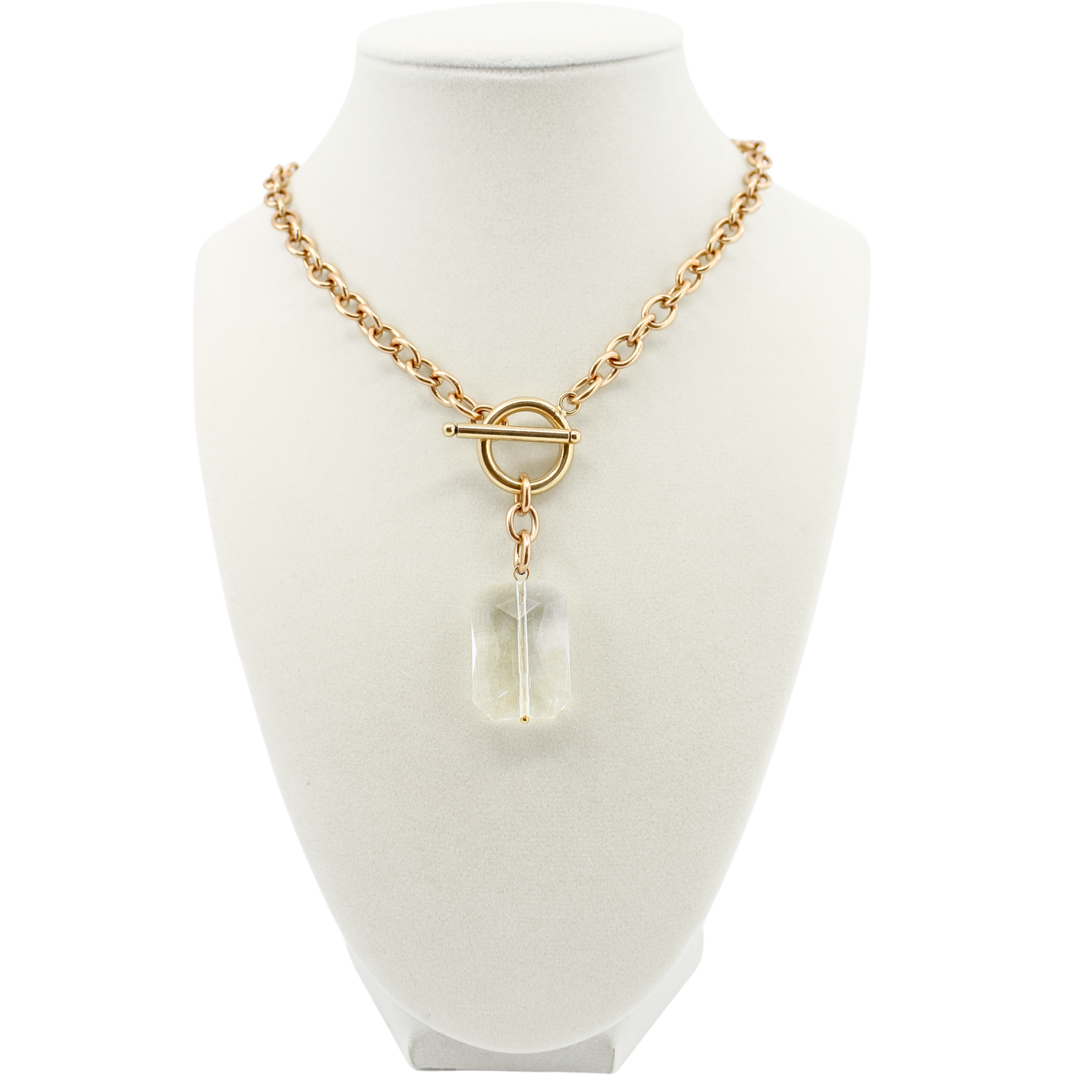 Gold necklace with a clear pendant on a mannequin bust against a white background
