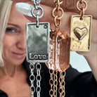 katia holds up gold and silver love heart original lite necklaces
