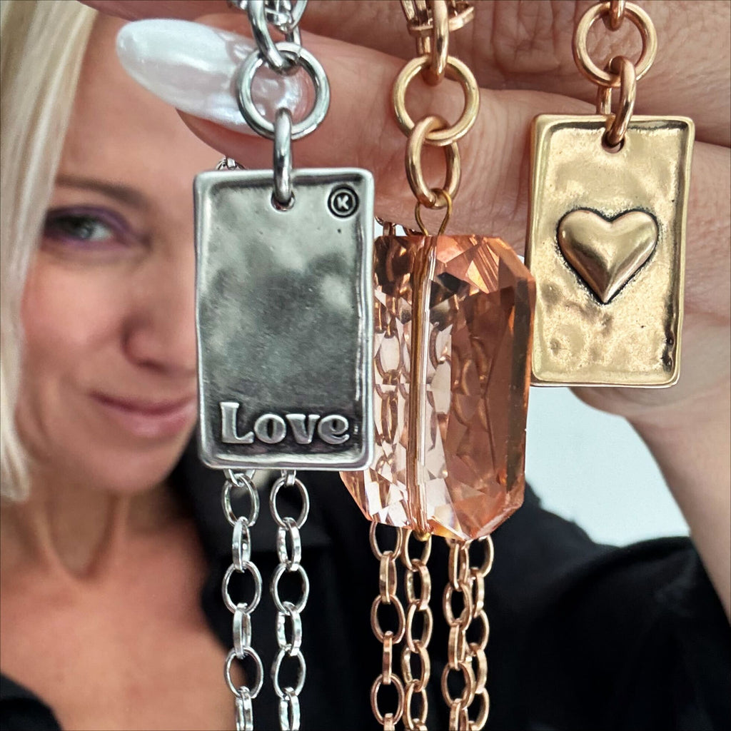 katia holds up gold and silver love heart original lite necklaces