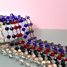 Colorful beaded necklaces on a pink and gray background