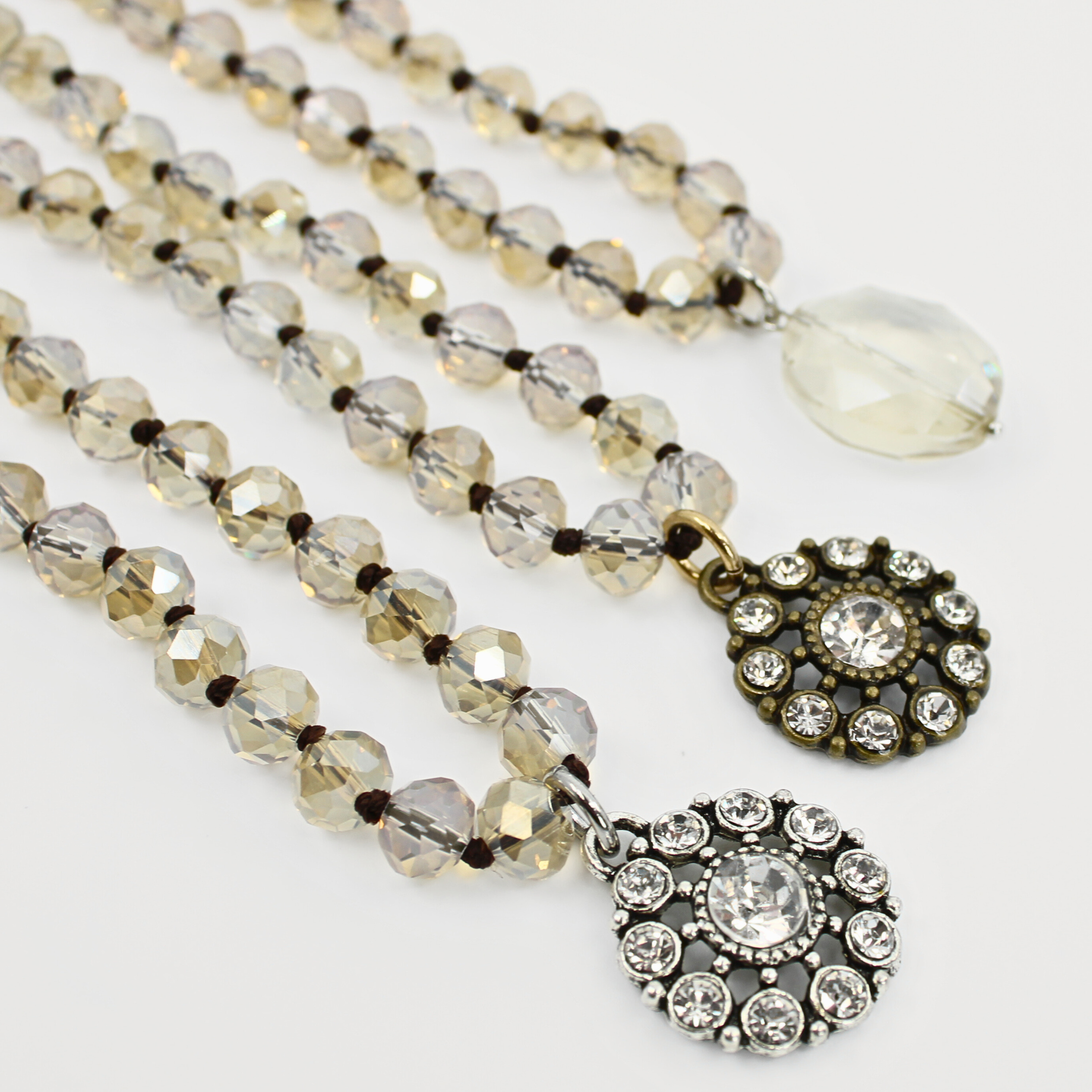 Layered beaded necklaces with faceted champagne crystal beads and two vintage-style round pendants adorned with sparkling clear crystals, designed by Katia Designs