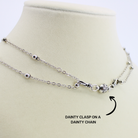 Silver necklace with a dainty clasp on a beige mannequin bust.